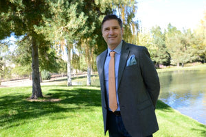 Pasquale Iovinella smiling at the camera wearing a necktie and pocket square