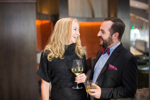 Man and Women looking at each other laughing holding a cocktail